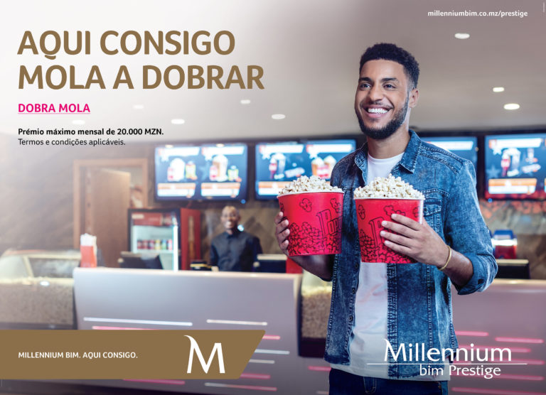 Rapaz modelo agarra dois pacotes de pipocas à entrada do cinema do Gloria Mall para a campanha publicitária do Millennium BIM Dobra Mola.
