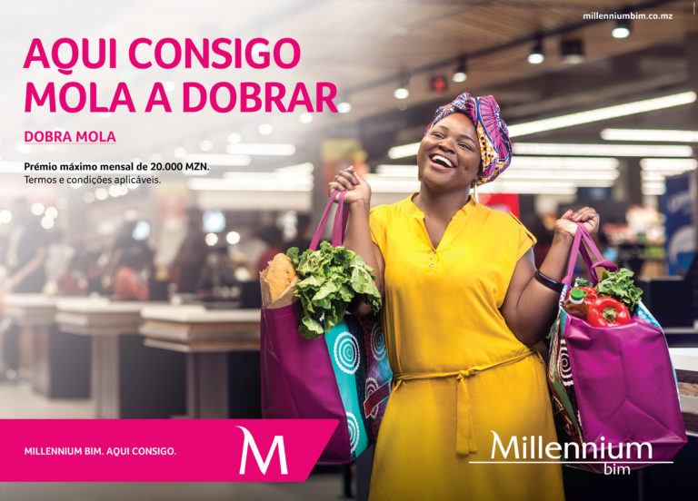 Rapariga Moçambicana, com uma linda capulana à cabeça, carrega alegremente dois sacos de compras com vegetais no Baía Mall, Maputo.